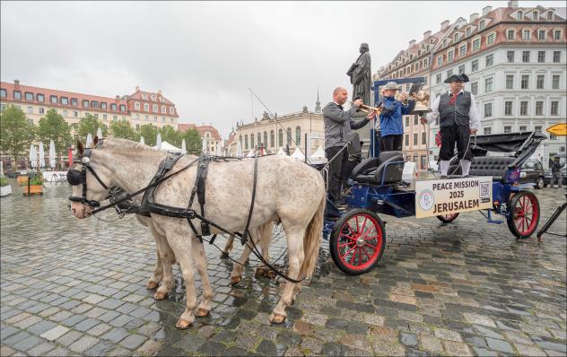 Start bei Regen in Dresden: 400 Kilometer lang ist die Strecke, die ein Pferdetreck mit Friedensbotschaft bis 22. August fahren möchte. Ein Verein will damit an verschiedenen Orten zum Gespräch einladen. © epd-bild/Matthias Rietschel