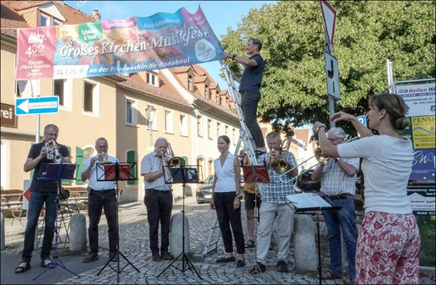 Zu den Klängen des Posaunenchors entfaltete Ingolf Miersch am Montag das große Banner auf dem Anger in Radebeul-Kötzschenbroda. © Birgit Andert