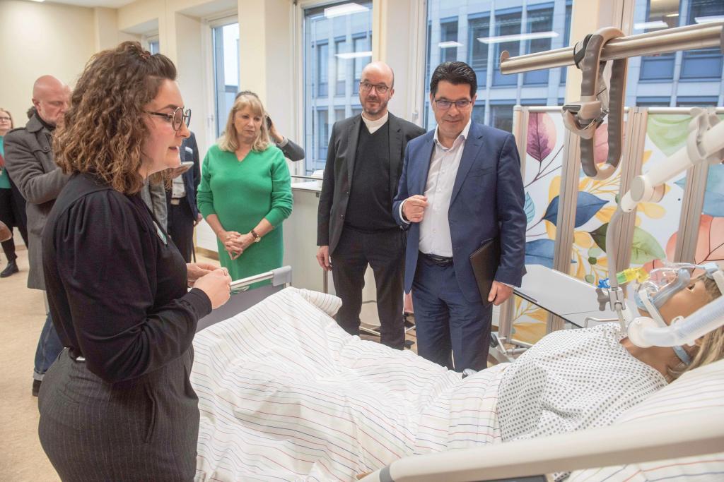 Besuch am Krankenbett (v. l.): Alisa Trummer (Leiterin des Simulationslabors), Petra Köpping (Sozialministerin), Landesbischof Tobias Bilz, Ronald Werner (Abteilungsleiter Hochschulen im Sächsischen Staatsministerium für Wissenschaft, Kultur und Tourismus) auf der nachgebauten Intensivstation des neuen EHS-Simulationslabors. Im Bett eine Patientin aus Kunststoff. © Dietrich Flechtner