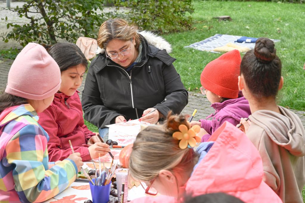 Kreativ im Ferdinandhof: Eine der ehrenamtlichen Helferinnen gestaltet mit den Kindern bunte Bilder. © Steffen Giersch